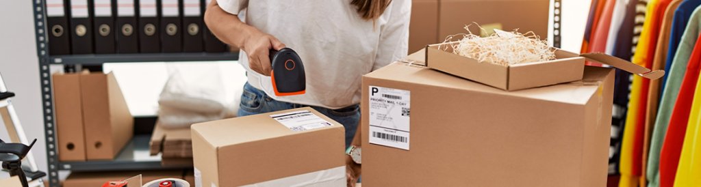 A woman scanning shipping label on a box