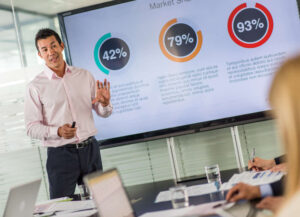 Man giving work presentation using large screen TV