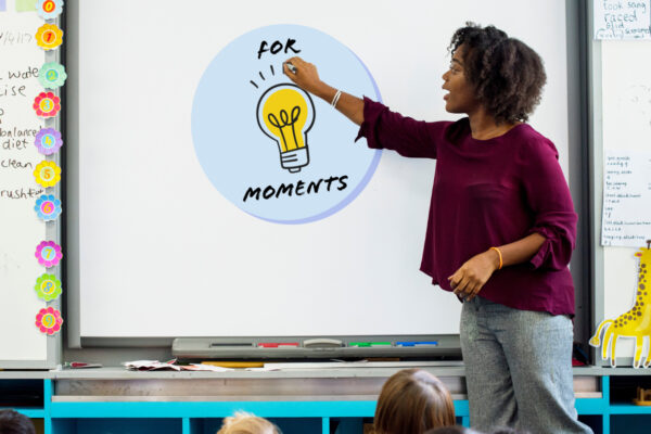 A teacher teaching in front of a whiteboard.