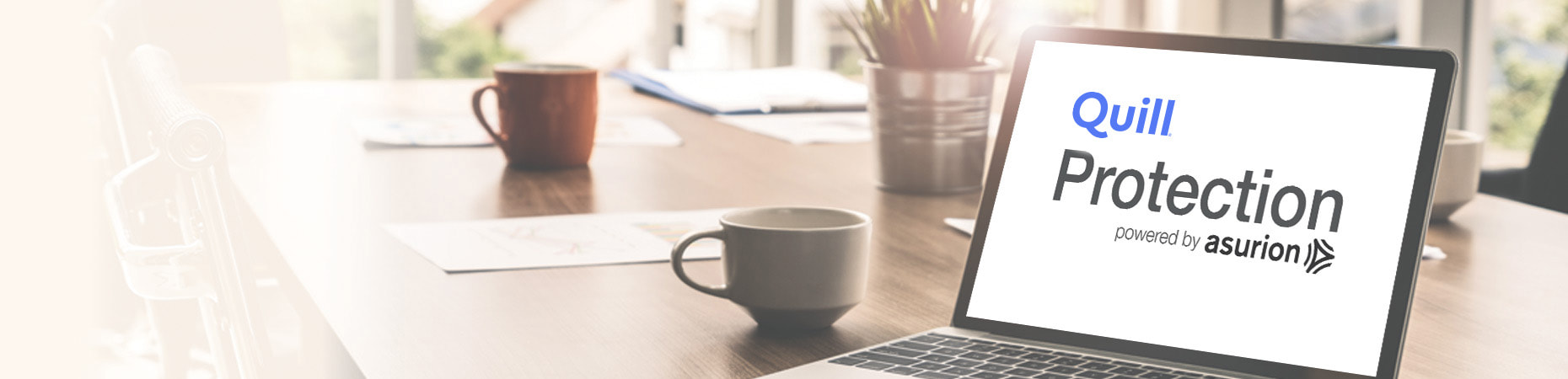 Laptop on a desk with coffee cups