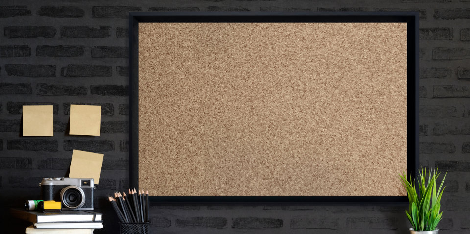 Cork board with black border in office.