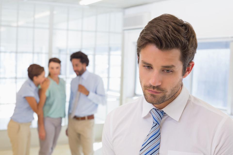 Group of co-workers gossiping about another co-worker