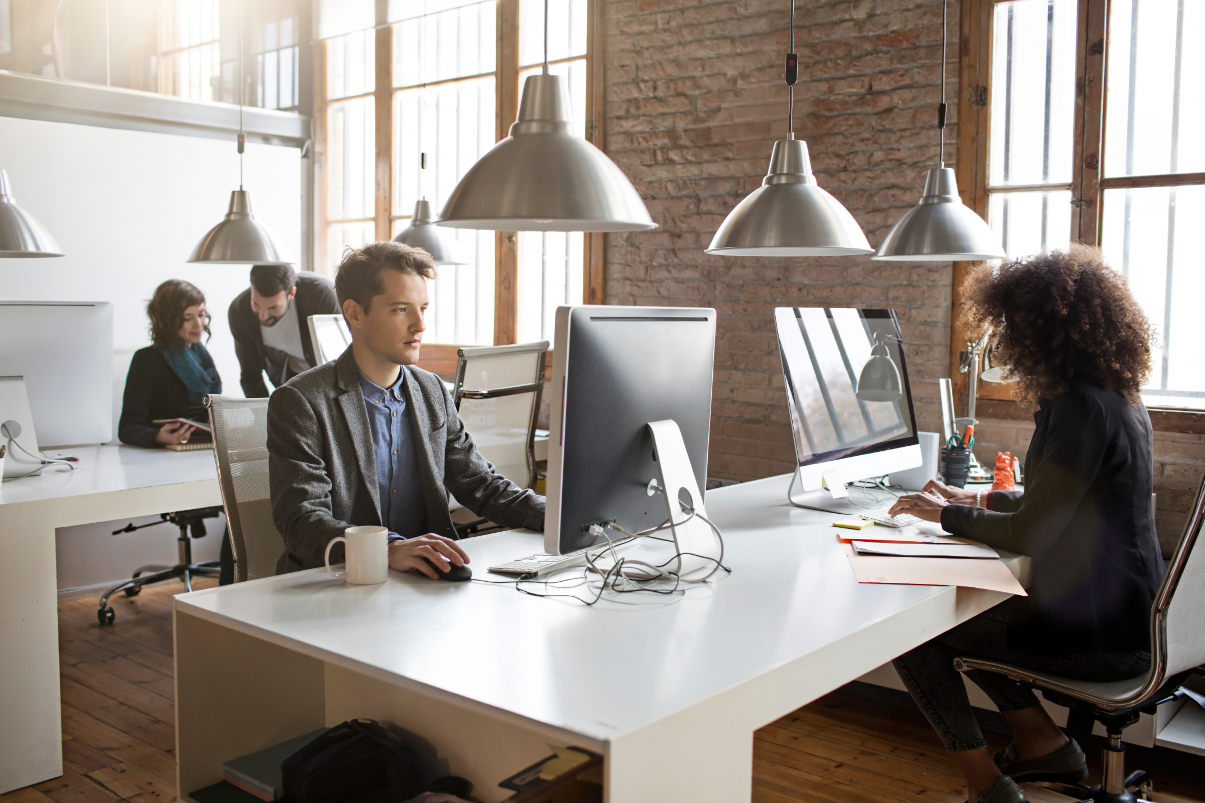 Employees working in clean, modern open-concept office space