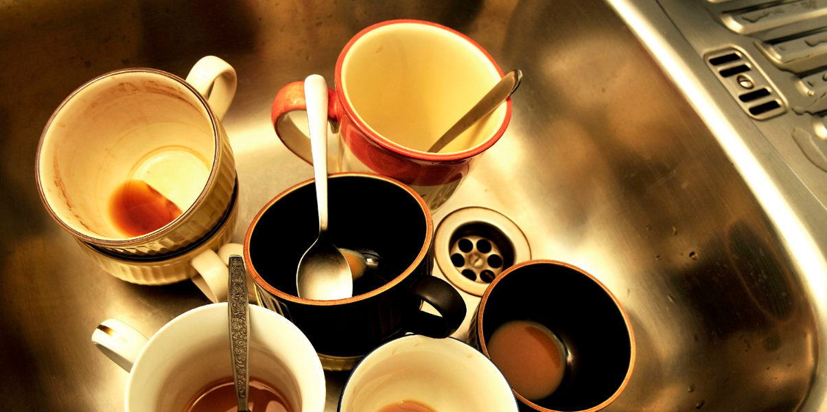 Sink full of dirty mugs.