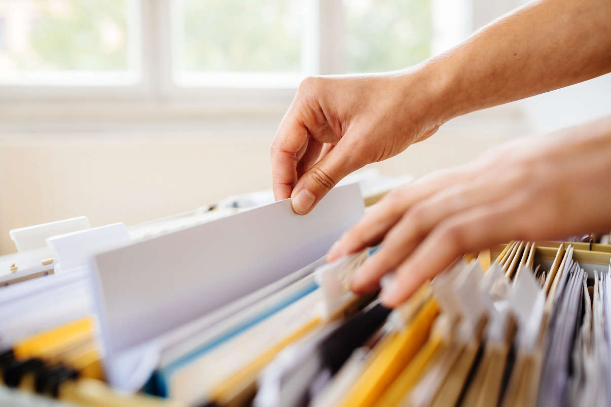 Hands browsing files in cabinet