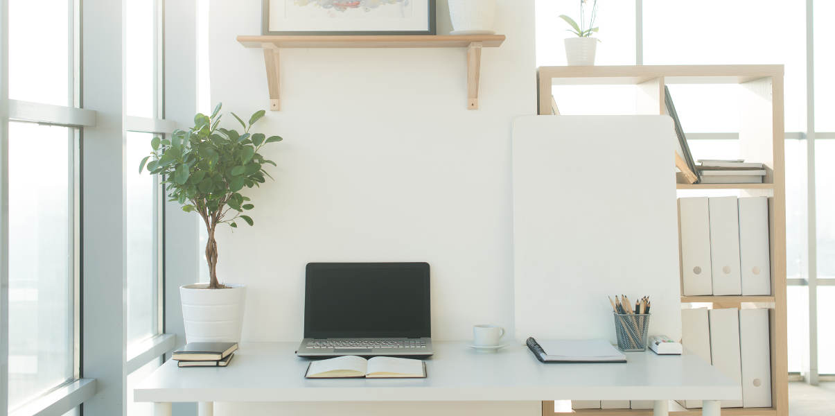 Studio workspace with a blank notebook and laptop