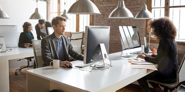 Employees working in clean, modern open-concept office space