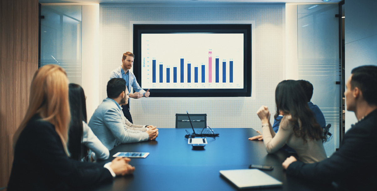 Man holding meeting in a conference room, using a screen to present.