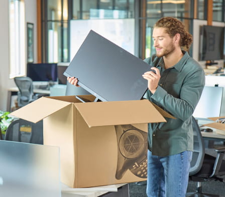 Image of a man holding a computer monitor