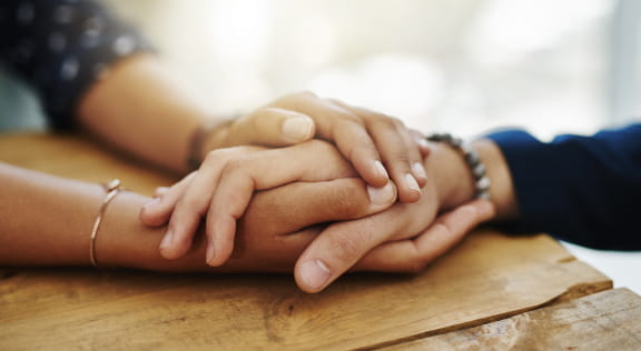 Image of two people holding hands