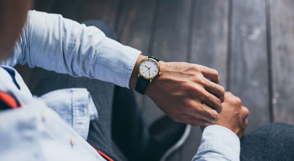 Image of a man looking at his watch